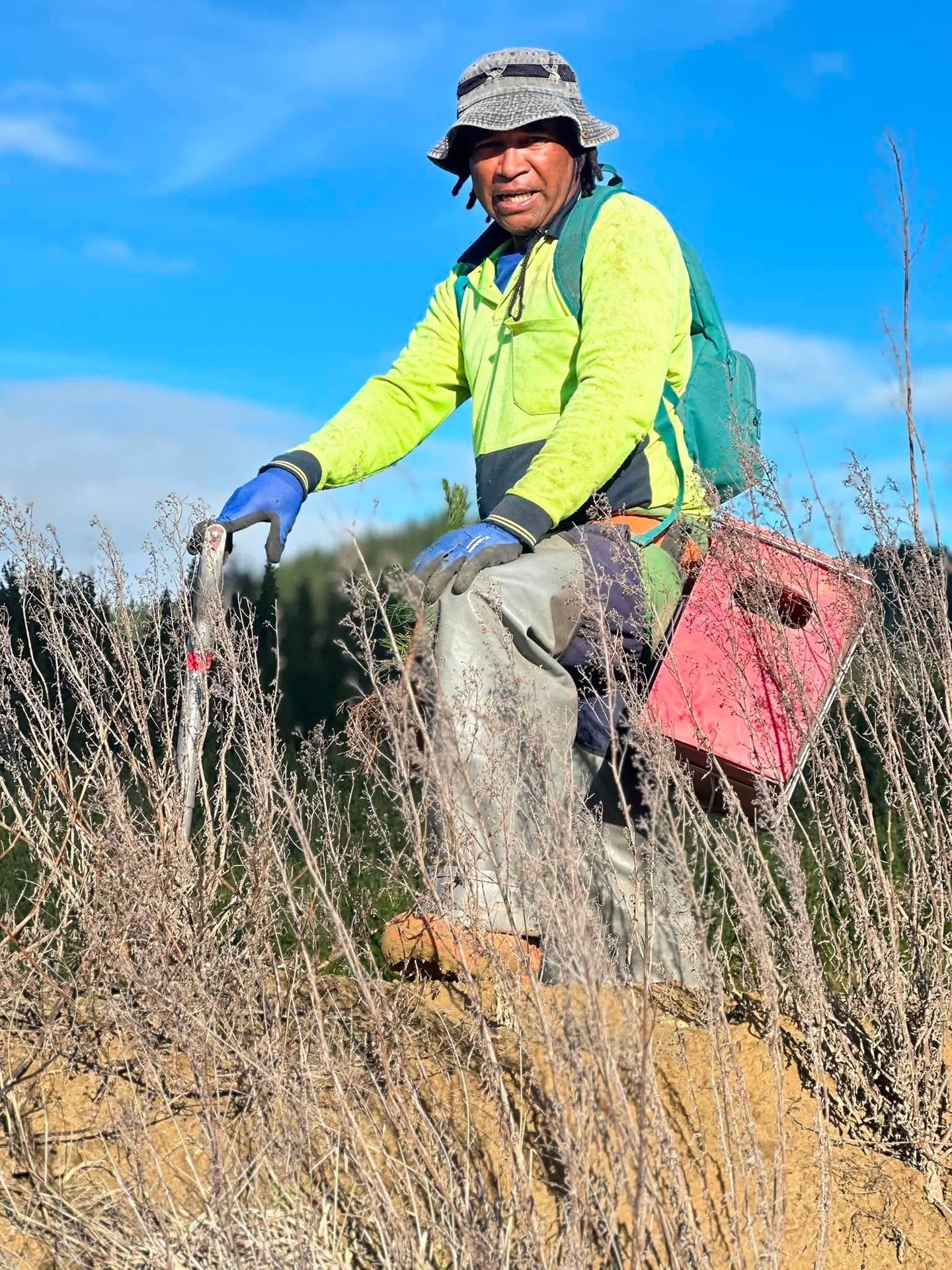 An FM Silvi planter on a hillside block carrying a planting box and spade